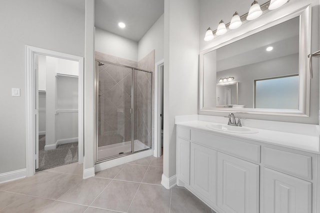 bathroom featuring a shower with door, tile patterned flooring, and vanity