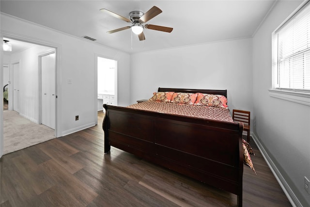 bedroom with ceiling fan, dark hardwood / wood-style floors, crown molding, and ensuite bath