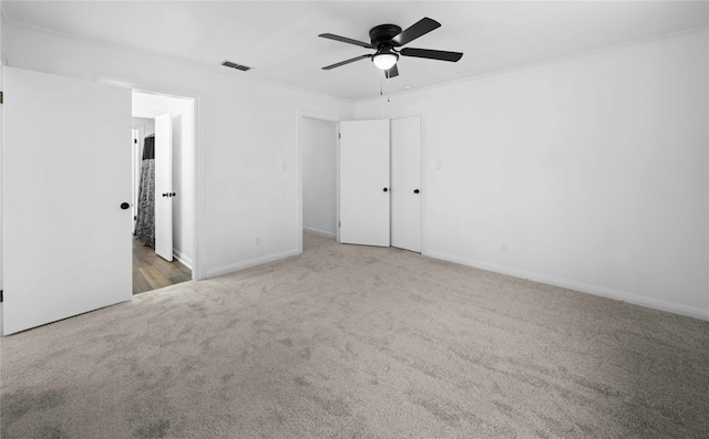 unfurnished bedroom featuring crown molding, carpet flooring, and ceiling fan