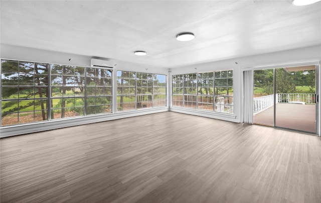 unfurnished sunroom with a wealth of natural light and a wall mounted air conditioner