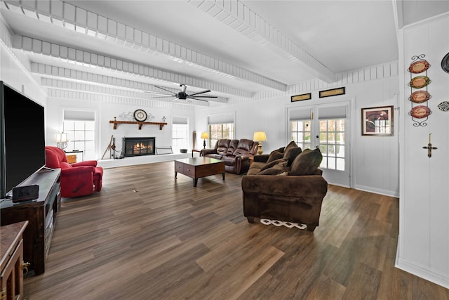 living room featuring dark wood-type flooring, ceiling fan, and beam ceiling