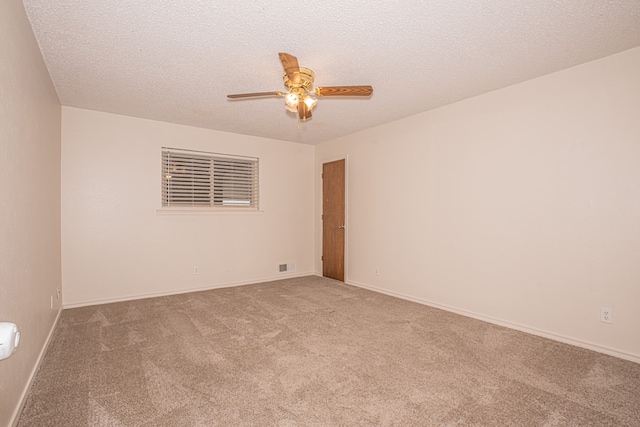 carpeted spare room with ceiling fan and a textured ceiling