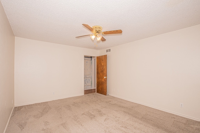 carpeted spare room with a textured ceiling and ceiling fan