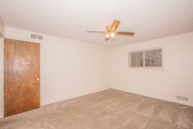 unfurnished room featuring ceiling fan, a textured ceiling, and carpet