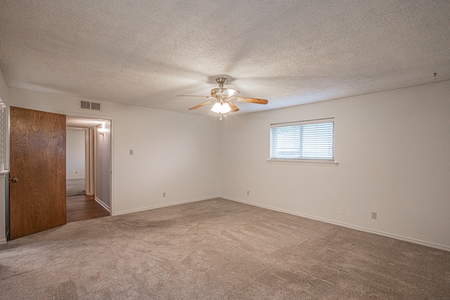 carpeted spare room featuring ceiling fan and a textured ceiling