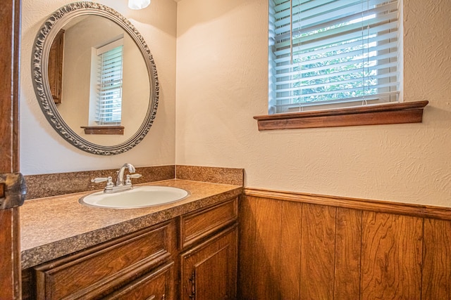 bathroom featuring vanity and wooden walls