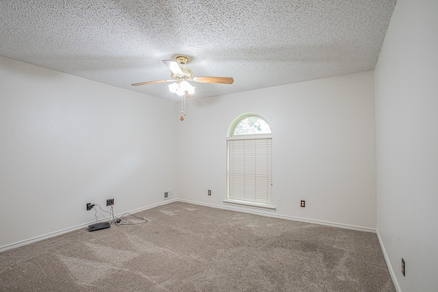 carpeted empty room featuring ceiling fan and a textured ceiling