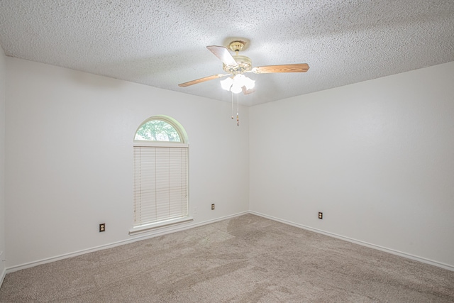 carpeted empty room featuring ceiling fan and a textured ceiling