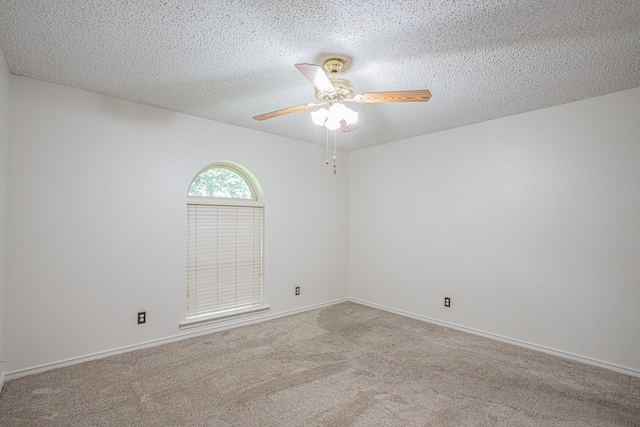 carpeted spare room with ceiling fan and a textured ceiling