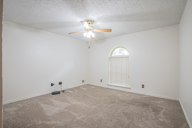 carpeted empty room featuring ceiling fan and a textured ceiling