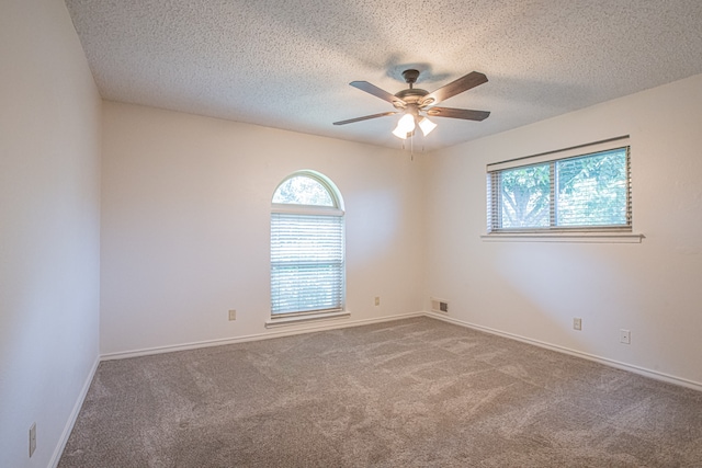 carpeted spare room featuring ceiling fan and a textured ceiling