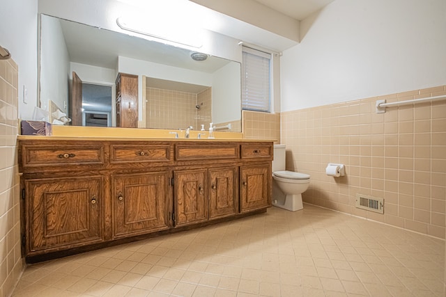 bathroom featuring vanity, tile walls, and toilet