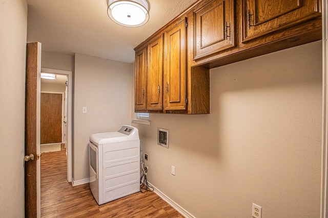 laundry room featuring cabinets, hardwood / wood-style flooring, and washer / dryer