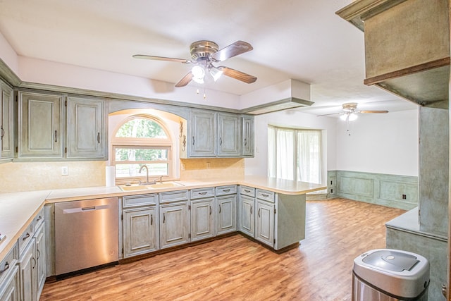 kitchen featuring kitchen peninsula, sink, stainless steel dishwasher, and light hardwood / wood-style flooring