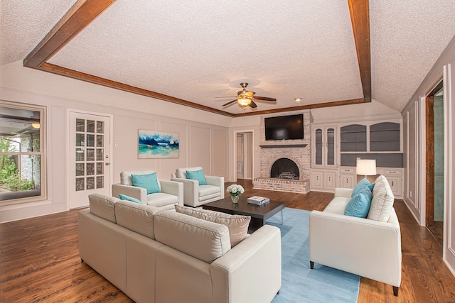 living room with ceiling fan, a textured ceiling, a fireplace, and hardwood / wood-style floors