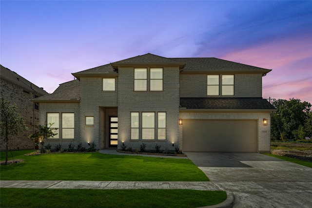 view of front of property with a yard and a garage