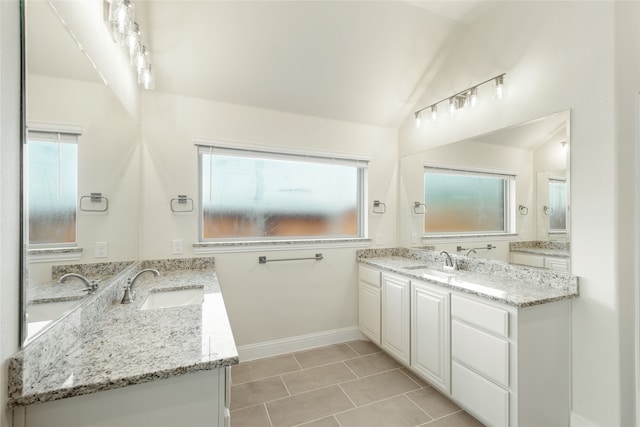 bathroom featuring vanity, lofted ceiling, and tile patterned flooring