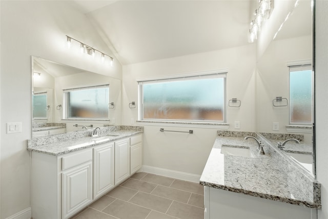 bathroom with vanity, lofted ceiling, and tile patterned flooring