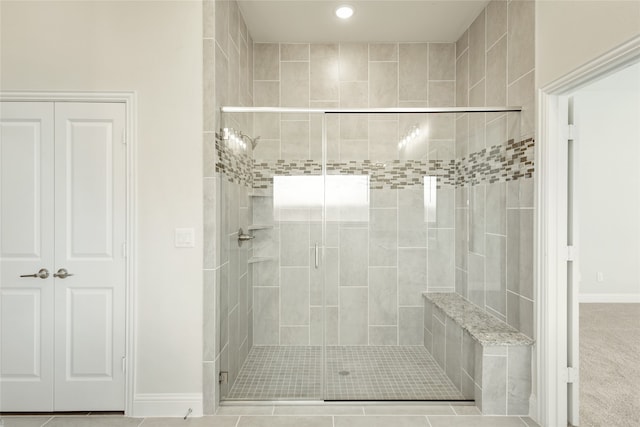 bathroom with a shower with shower door and tile patterned floors