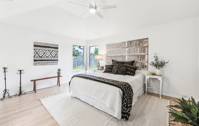 bedroom with ceiling fan, hardwood / wood-style flooring, and vaulted ceiling