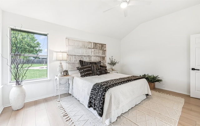 bedroom featuring light hardwood / wood-style flooring, ceiling fan, and vaulted ceiling