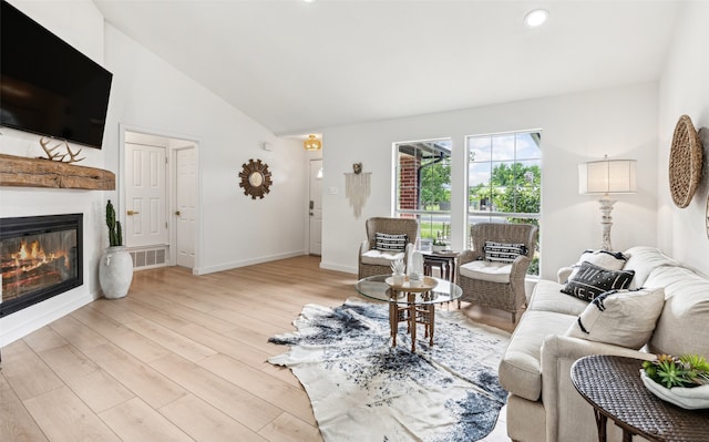 living room with vaulted ceiling and light hardwood / wood-style flooring