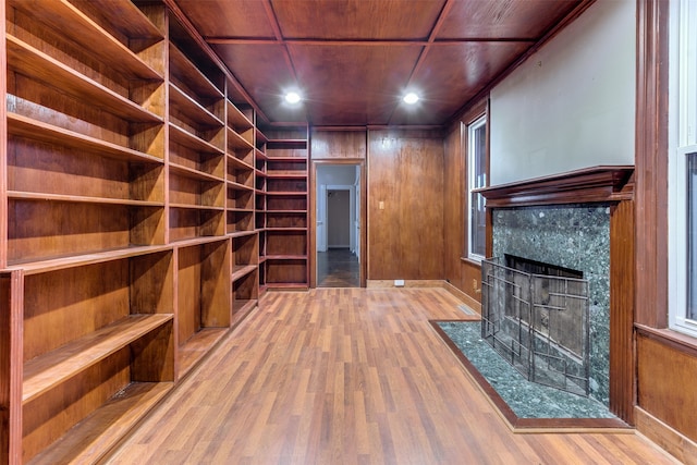 interior space with wood ceiling, wood walls, hardwood / wood-style floors, and a fireplace