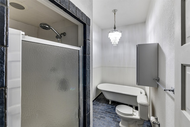 bathroom with toilet, a chandelier, and separate shower and tub