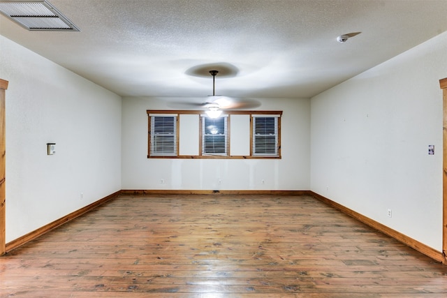 spare room with a textured ceiling, ceiling fan, and hardwood / wood-style flooring