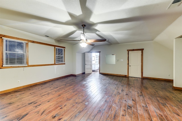 interior space with ceiling fan, dark hardwood / wood-style floors, a textured ceiling, and vaulted ceiling