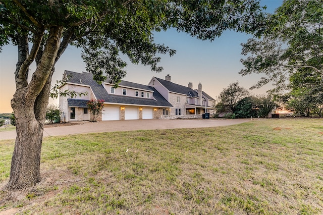 view of front of property featuring a garage and a lawn