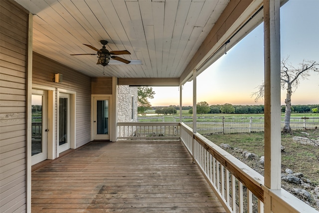 deck at dusk featuring ceiling fan and a rural view