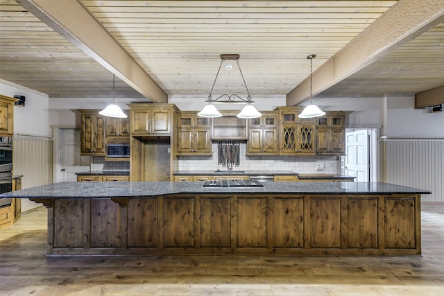 kitchen featuring hardwood / wood-style floors, pendant lighting, stainless steel appliances, and beamed ceiling