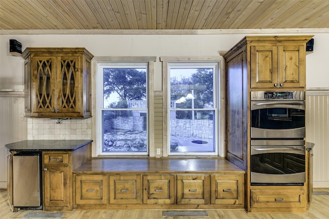 kitchen featuring light wood-type flooring, stainless steel appliances, and decorative backsplash