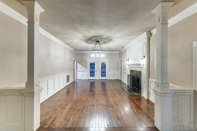 unfurnished living room featuring a fireplace, french doors, ornamental molding, and dark hardwood / wood-style floors