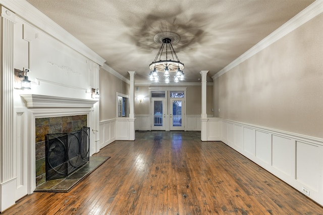 interior space with a fireplace, crown molding, french doors, a chandelier, and dark hardwood / wood-style floors