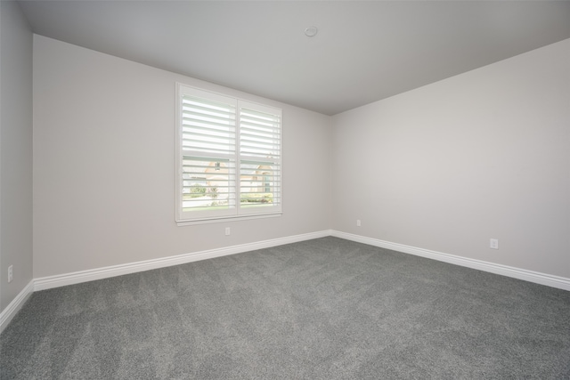 unfurnished room with dark carpet