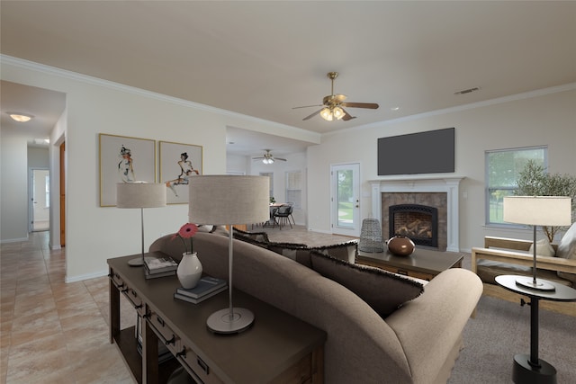 living room with a tile fireplace, crown molding, ceiling fan, and light tile patterned floors