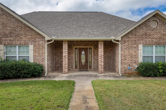 entrance to property featuring a lawn