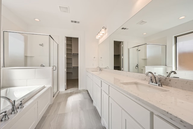 bathroom featuring vanity and independent shower and bath