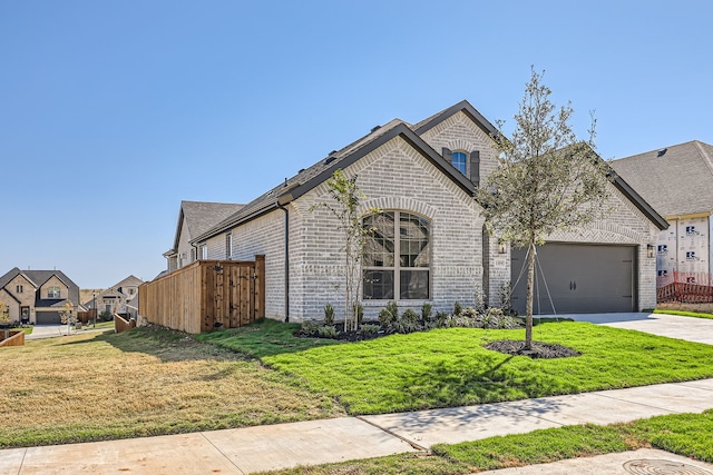 french country inspired facade featuring a front yard and a garage