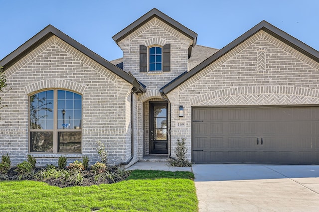 view of front of property with a garage and a front lawn