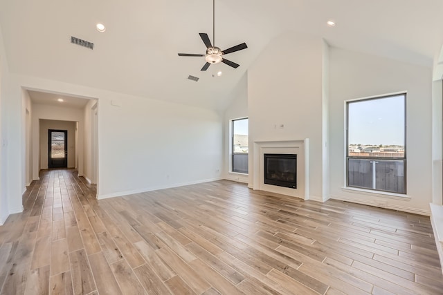 unfurnished living room with light hardwood / wood-style floors, high vaulted ceiling, and ceiling fan