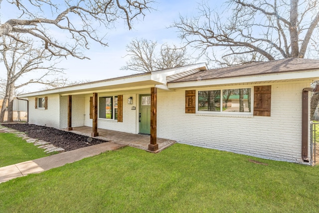 ranch-style house featuring a front lawn and a patio