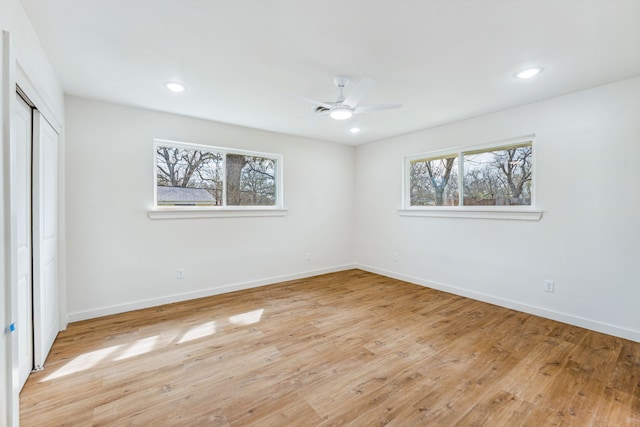 unfurnished bedroom featuring multiple windows, ceiling fan, a closet, and light hardwood / wood-style flooring