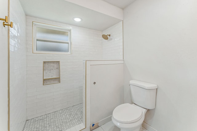 bathroom with toilet and a tile shower