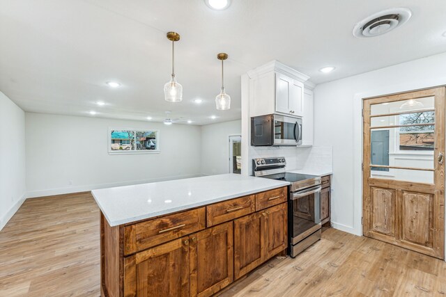 kitchen featuring tasteful backsplash, appliances with stainless steel finishes, white cabinetry, and light hardwood / wood-style floors