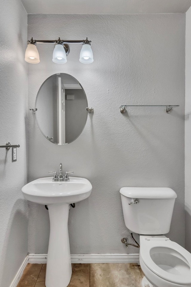 bathroom featuring tile patterned flooring, toilet, and sink