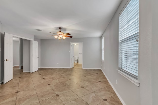 tiled spare room with ceiling fan