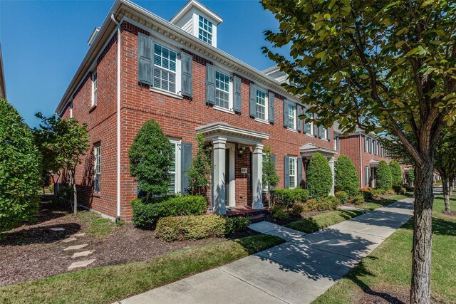 colonial inspired home with a front lawn